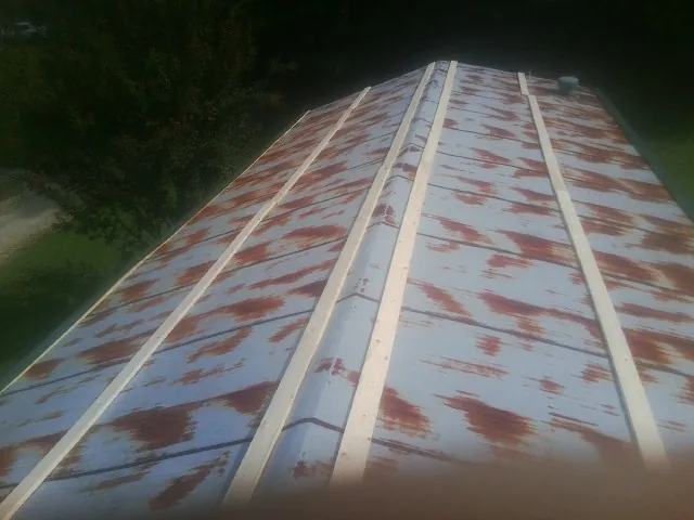 Rusted metal roof panels with new wood purlins before replacement — Storm Damage Roof Repair in Perley by Roofing Brothers