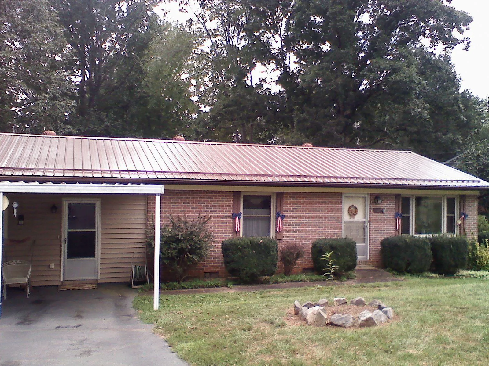 Bronze metal roof and carport on a brick ranch home — Roof Repair work by our crew in Perley